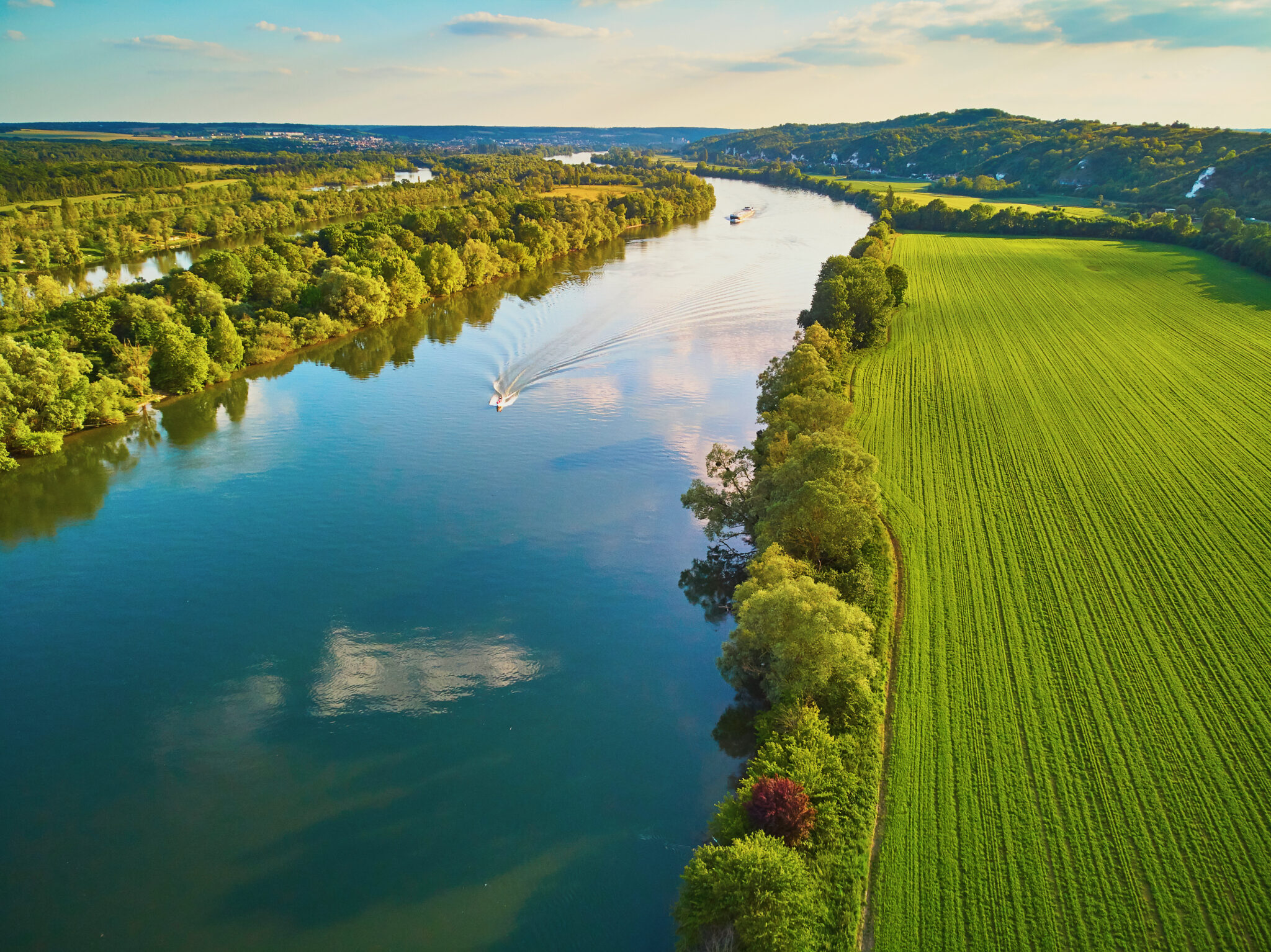 Scenic aerial view of the Seine river and green fields in French countryside. Val d'Oise department, Ile-de-France, Northern France