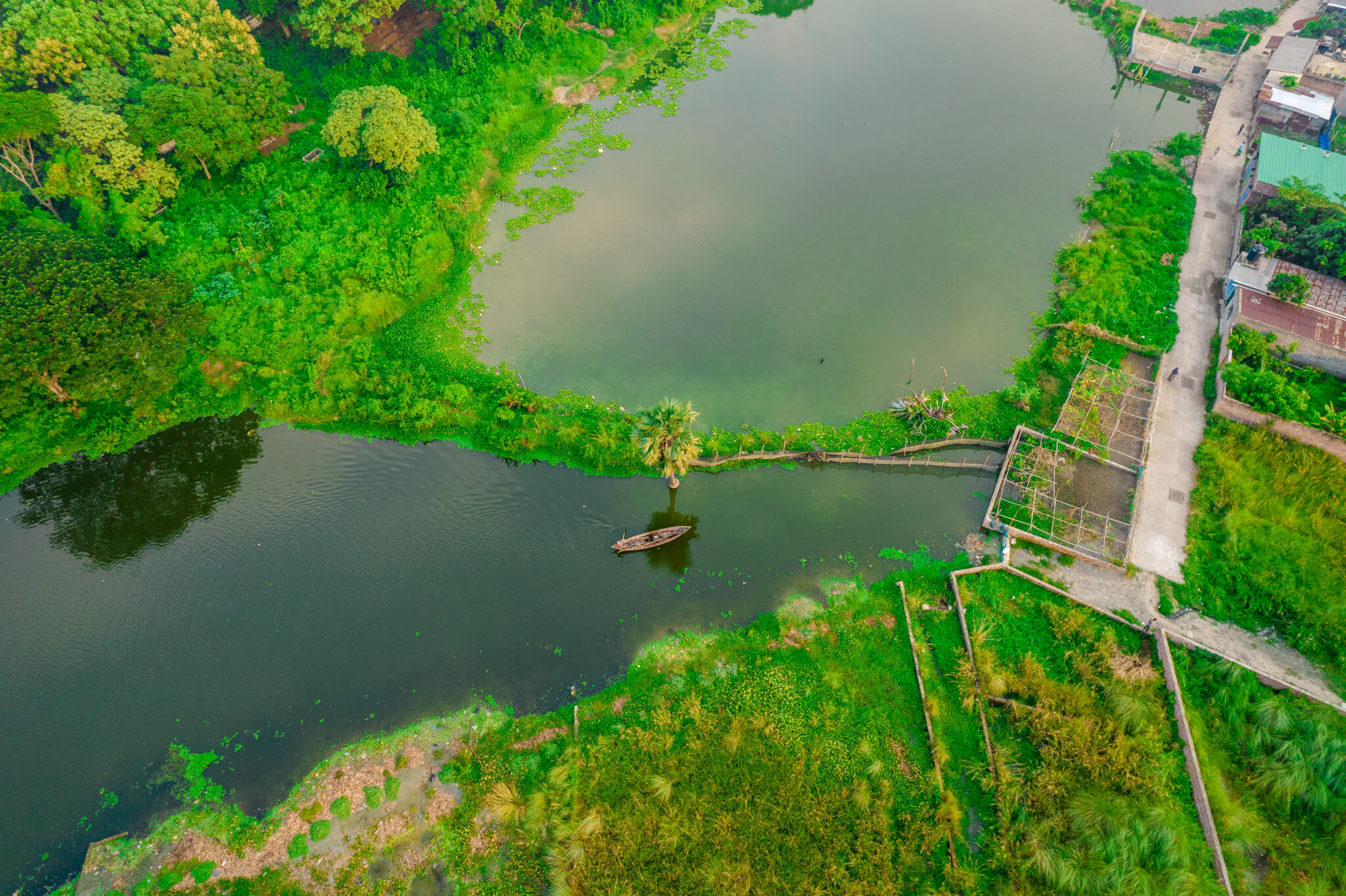 A river boat in Dhaka, Bangladesh surrounded by greenery